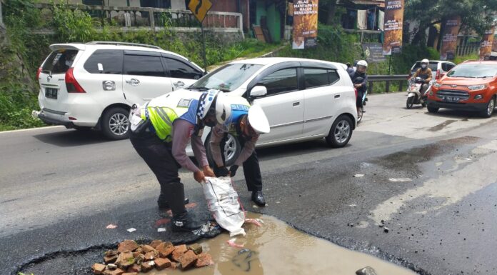 Cegah kecelakaan, Anggota Satlantas Polres Sukabumi Tambal Jalan Berlubang di Tanjakan Pamuruyan Cibadak polsek cibadak
